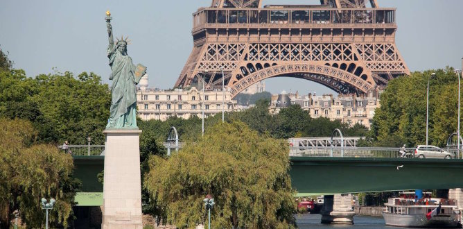 The Statue of Liberty towers above the Seine River in Paris